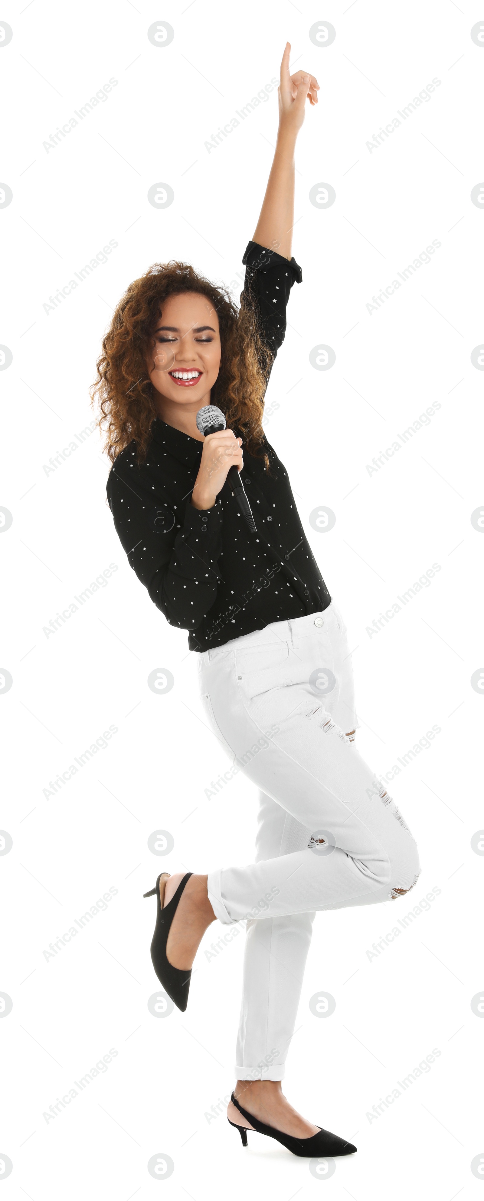 Photo of Curly African-American woman in stylish clothes singing with microphone on white background