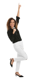 Curly African-American woman in stylish clothes singing with microphone on white background