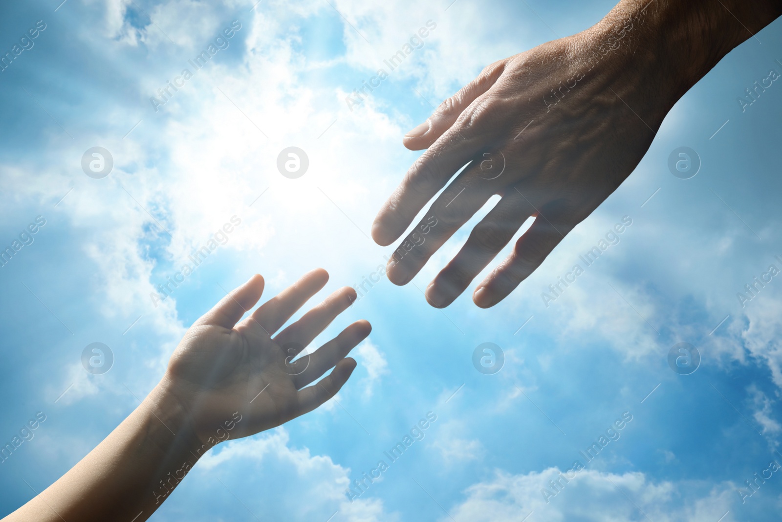 Image of Godparent with child and beautiful blue sky with fluffy clouds on background, closeup