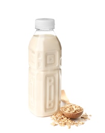 Bottle with oat milk and flakes on white background