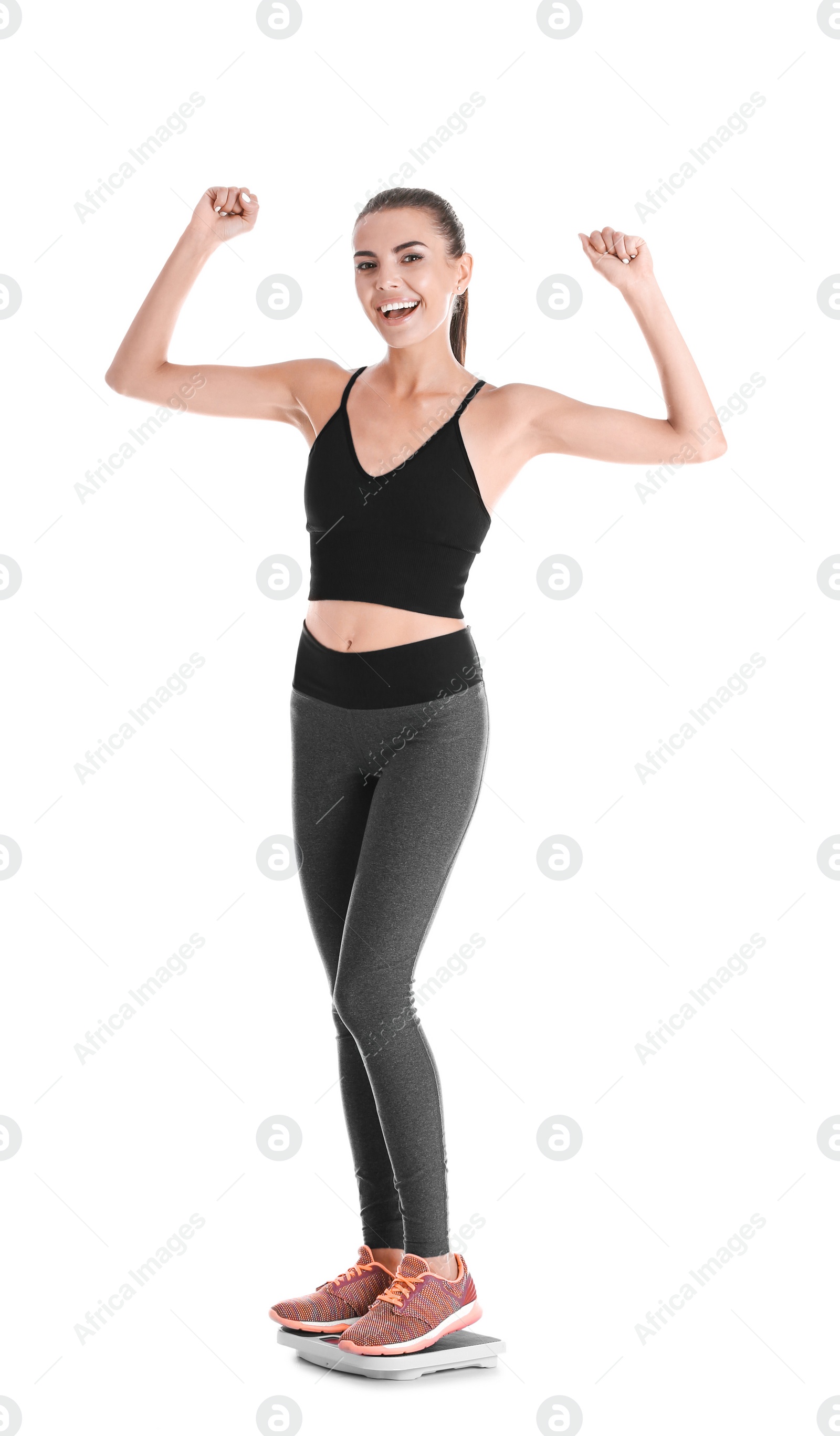 Photo of Happy young woman measuring her weight using scales on white background. Weight loss motivation