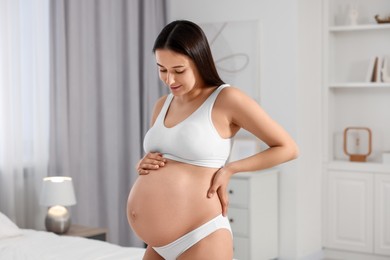 Photo of Beautiful pregnant woman wearing stylish comfortable underwear in bedroom