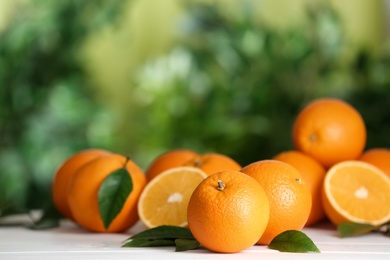 Fresh ripe oranges on white table against blurred background. Space for text