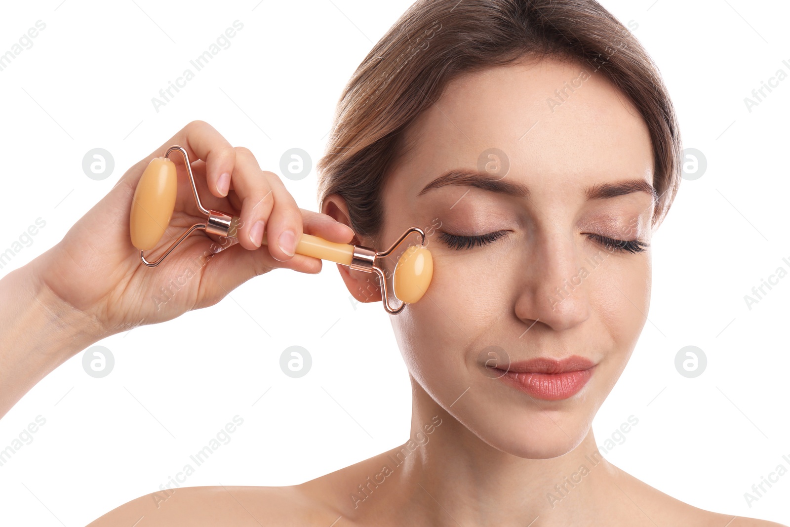 Photo of Young woman using natural jade face roller on white background, closeup
