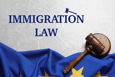 Image of Immigration law. Judge's gavel and flag of European Union on light grey marble table, top view