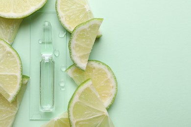 Pharmaceutical ampoule with medication and lime slices on turquoise background, flat lay. Space for text