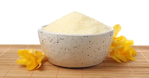 Photo of Natural sea salt in bowl and flowers on bamboo mat against white background