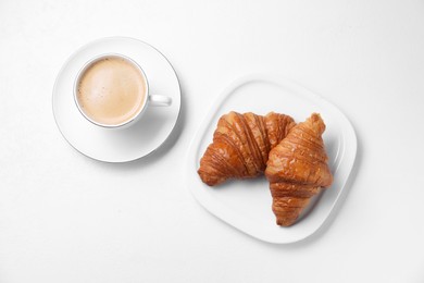 Photo of Fresh croissants and coffee on white background, flat lay. Tasty breakfast