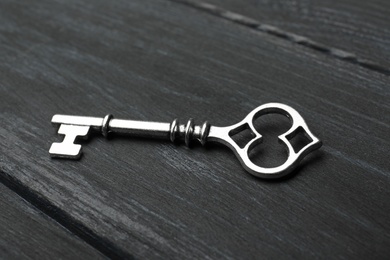 Old vintage key on wooden background, closeup