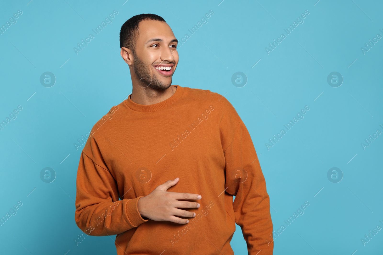 Photo of Portrait of happy African American man on light blue background. Space for text