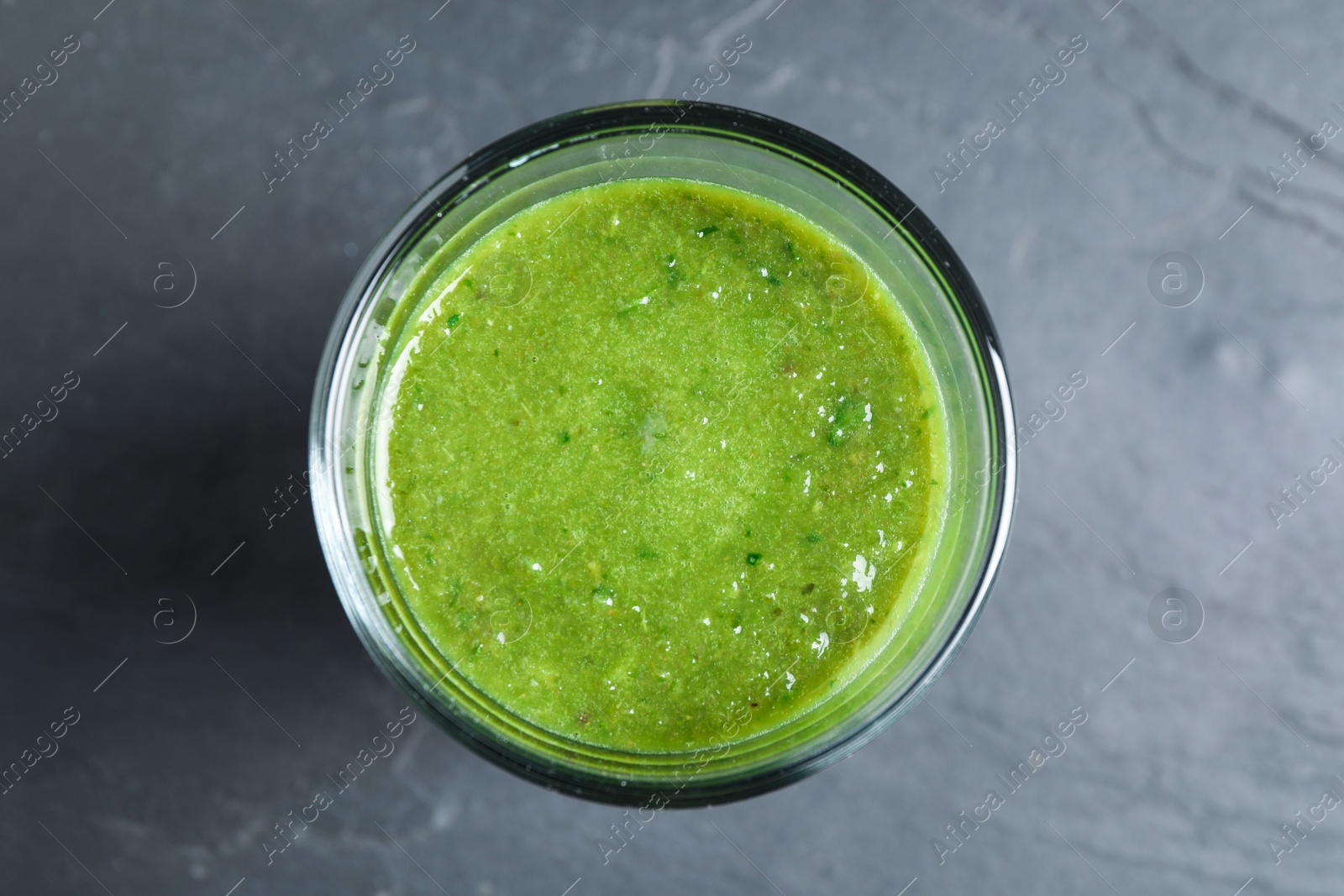 Photo of Delicious fresh green juice on black table, top view
