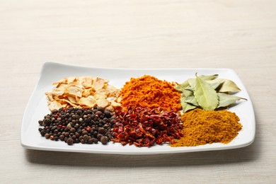 Photo of Plate with different spices on light table