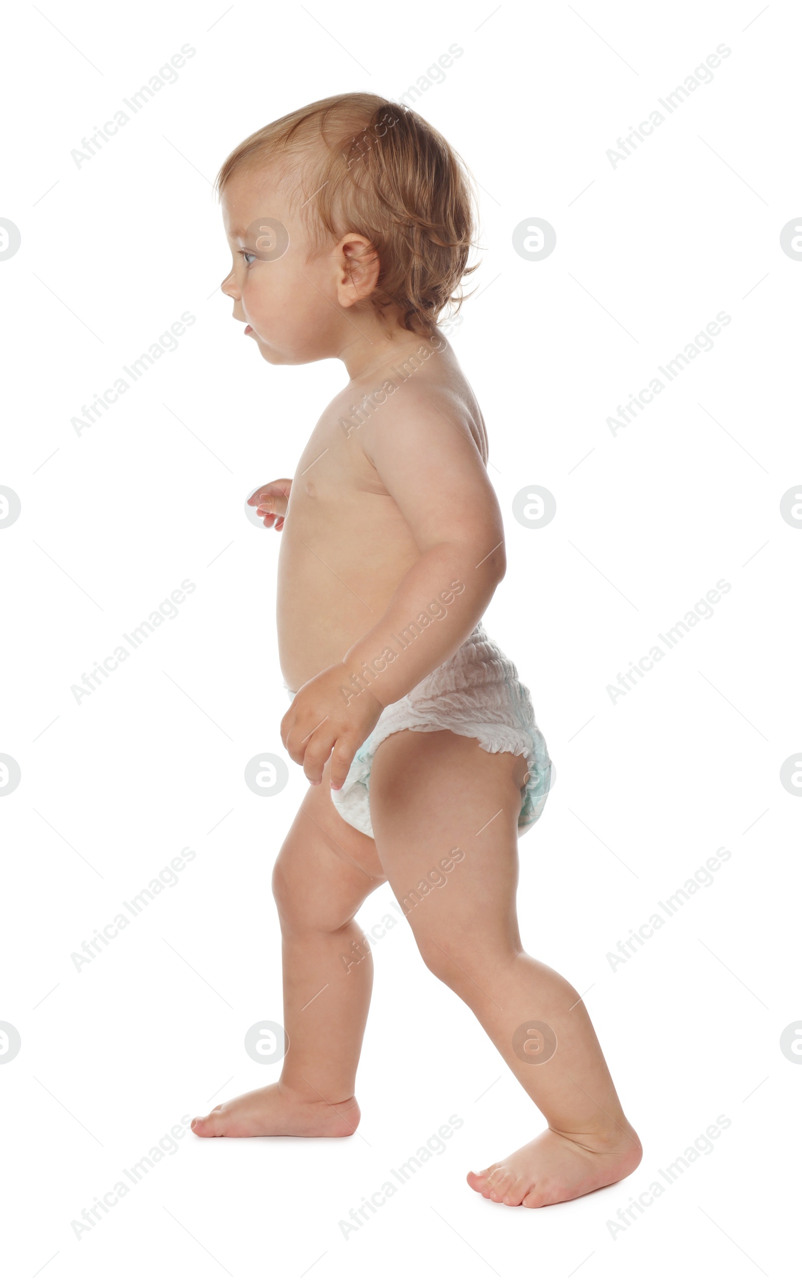 Photo of Cute baby in diaper learning to walk on white background