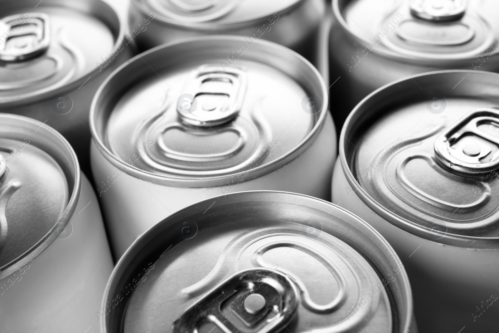 Photo of Aluminum cans with cold beverage as background, closeup