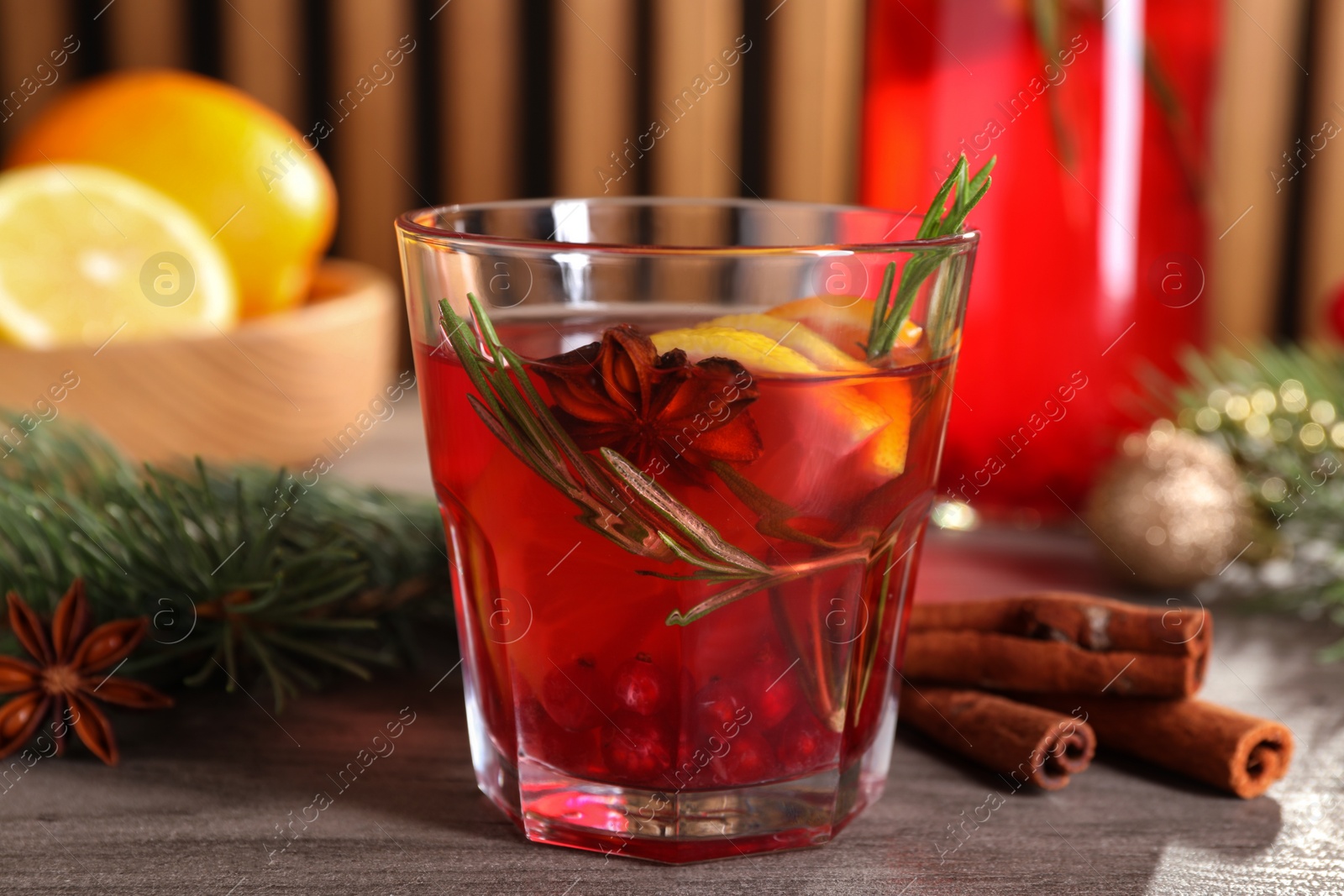 Photo of Aromatic punch drink and fir tree branch on wooden table, closeup