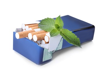 Pack of menthol cigarettes and fresh mint leaves on white background