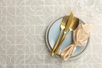 Stylish setting with cutlery, plates, napkin and glasses on table, top view. Space for text