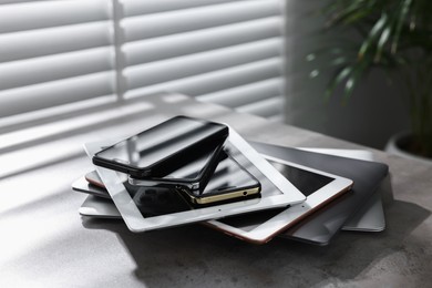 Photo of Many different modern gadgets on grey table indoors. Space for text