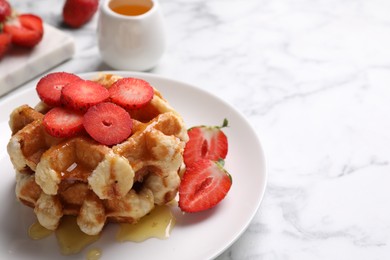 Photo of Delicious Belgian waffles with strawberries and honey on white marble table, closeup. Space for text