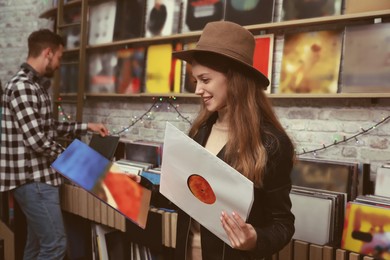 Image of Young woman with vinyl records in store