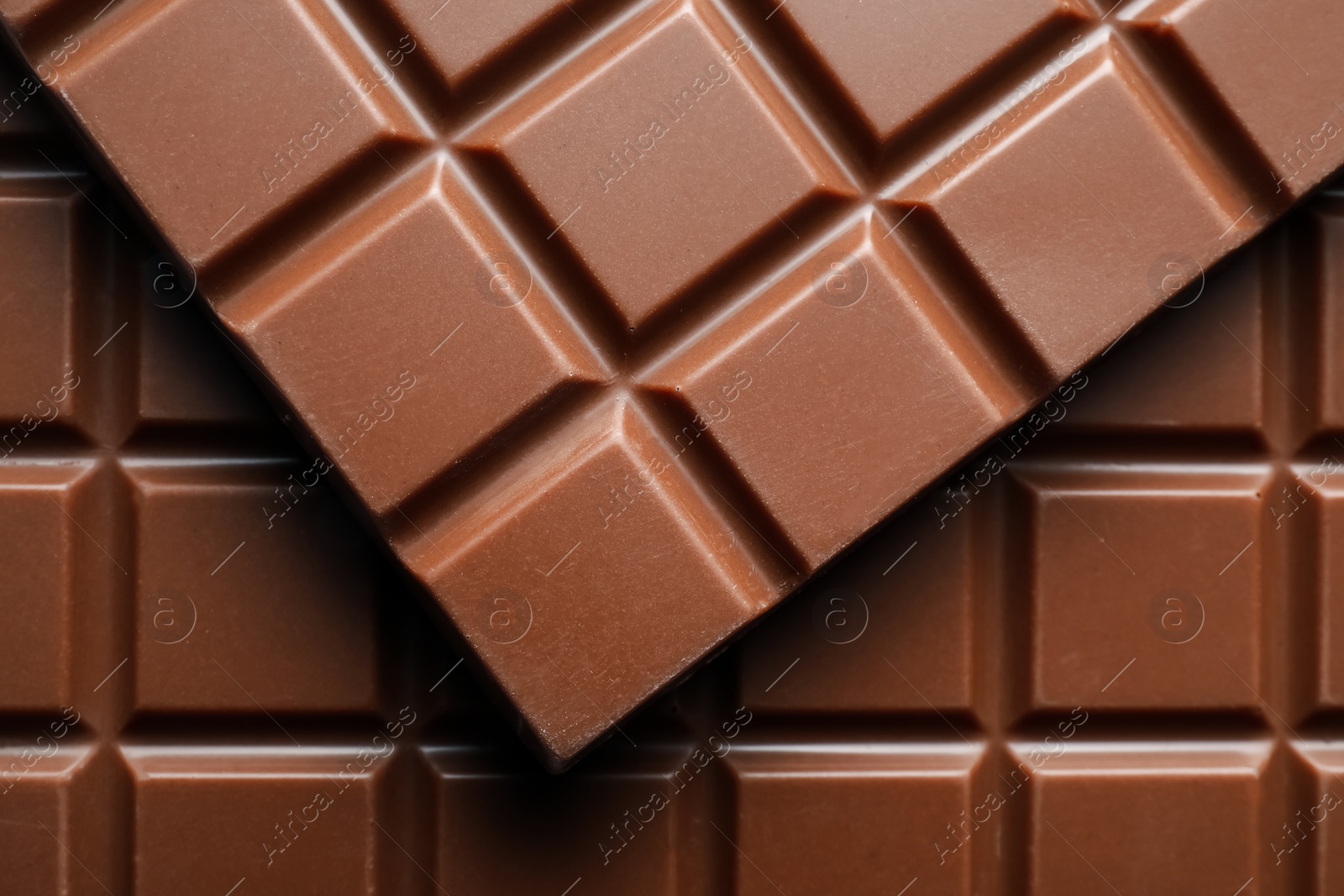 Photo of Delicious milk chocolate bars as background, top view