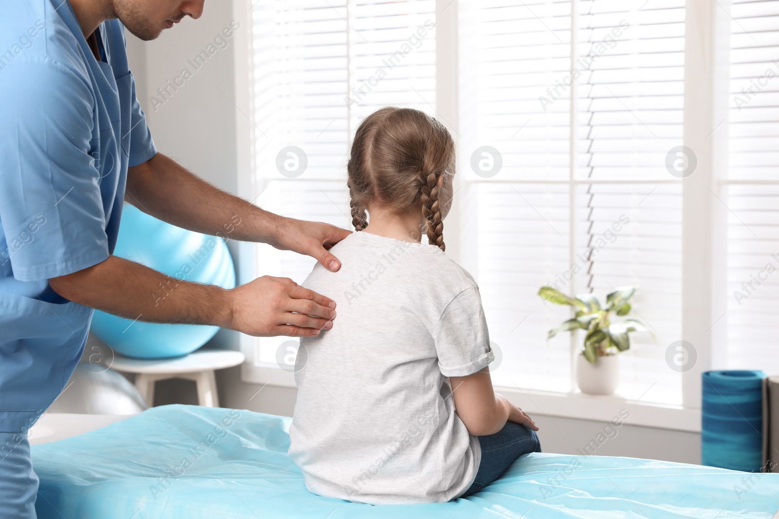 Photo of Orthopedist examining child's back in clinic, closeup. Scoliosis treatment