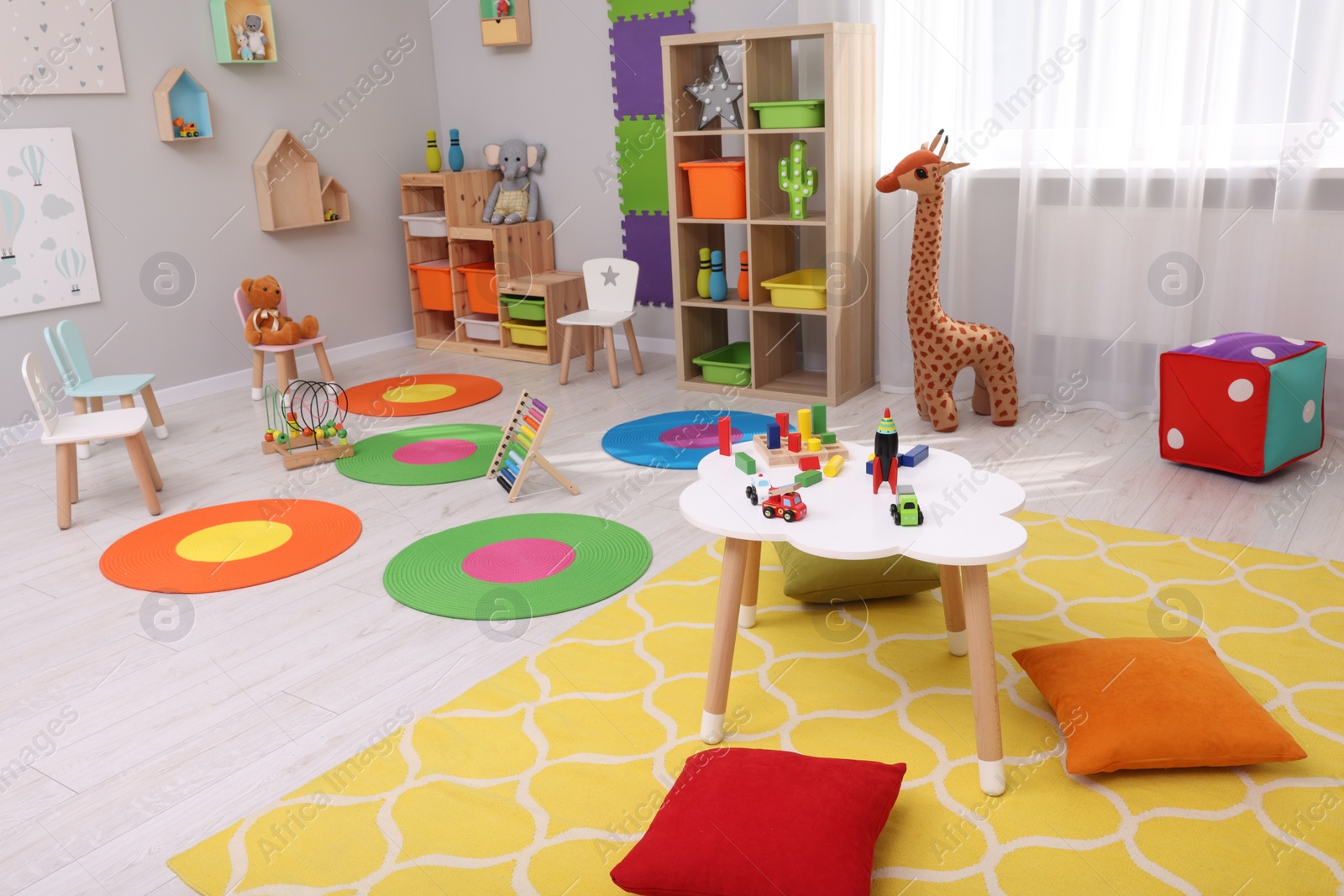 Photo of Child`s playroom with different toys and furniture. Cozy kindergarten interior