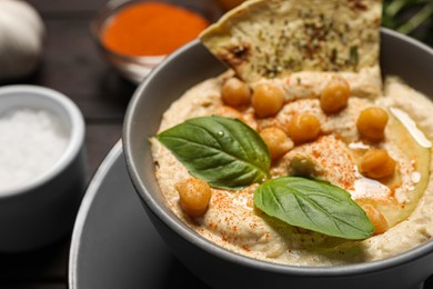 Photo of Delicious creamy hummus with chickpeas and chips on table, closeup