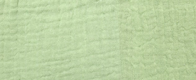 Texture of light green fabric as background, top view