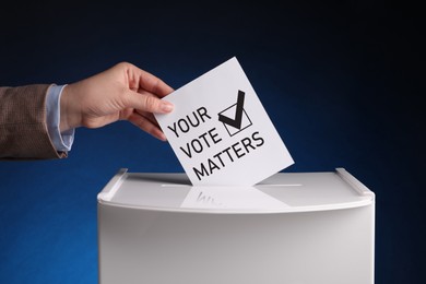 Woman putting paper with text Your Vote Matters and tick into ballot box on dark blue background