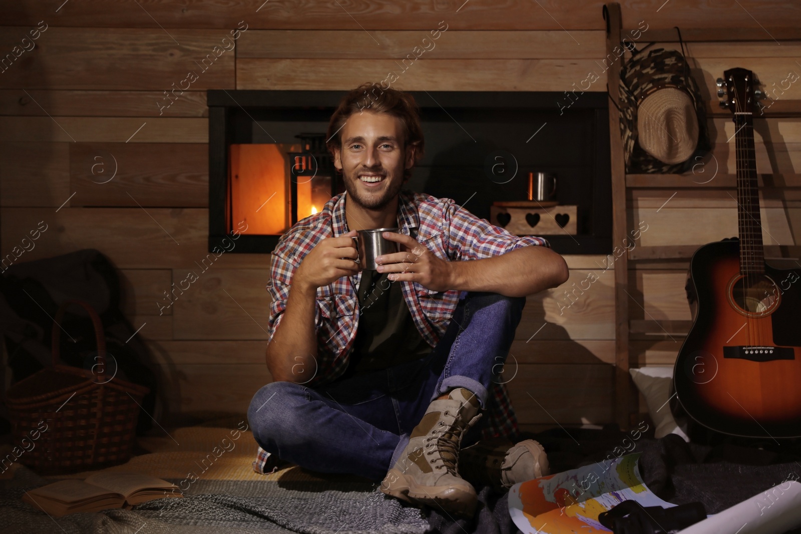 Photo of Handsome young traveler with mug indoors