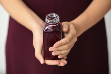 Woman with bottle of beet smoothie, closeup