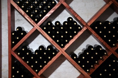 Photo of Many bottles of wine on shelves in cellar