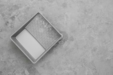 Photo of Container with white paint on floor, top view. Space for text