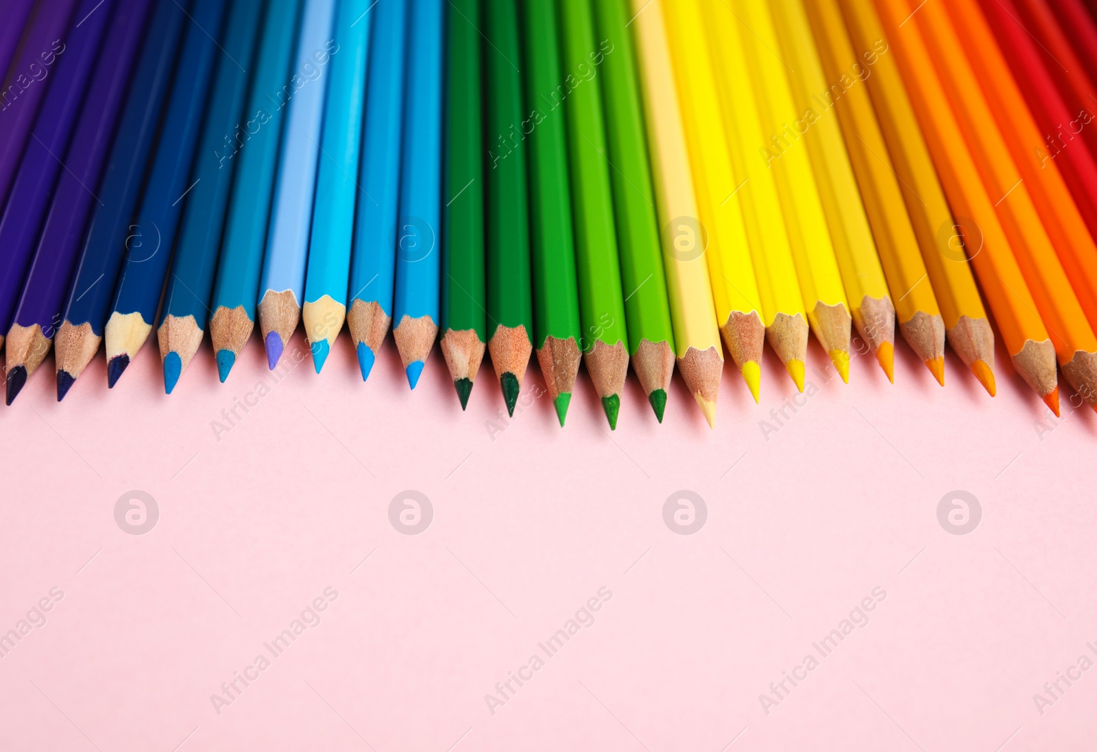 Photo of Composition with color pencils on pink background