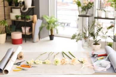 Photo of Florist workplace with tools and parchment on table