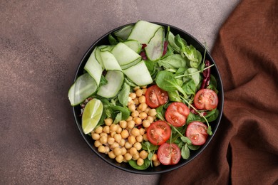 Tasty salad with chickpeas, cherry tomatoes and cucumbers on grey textured table, top view