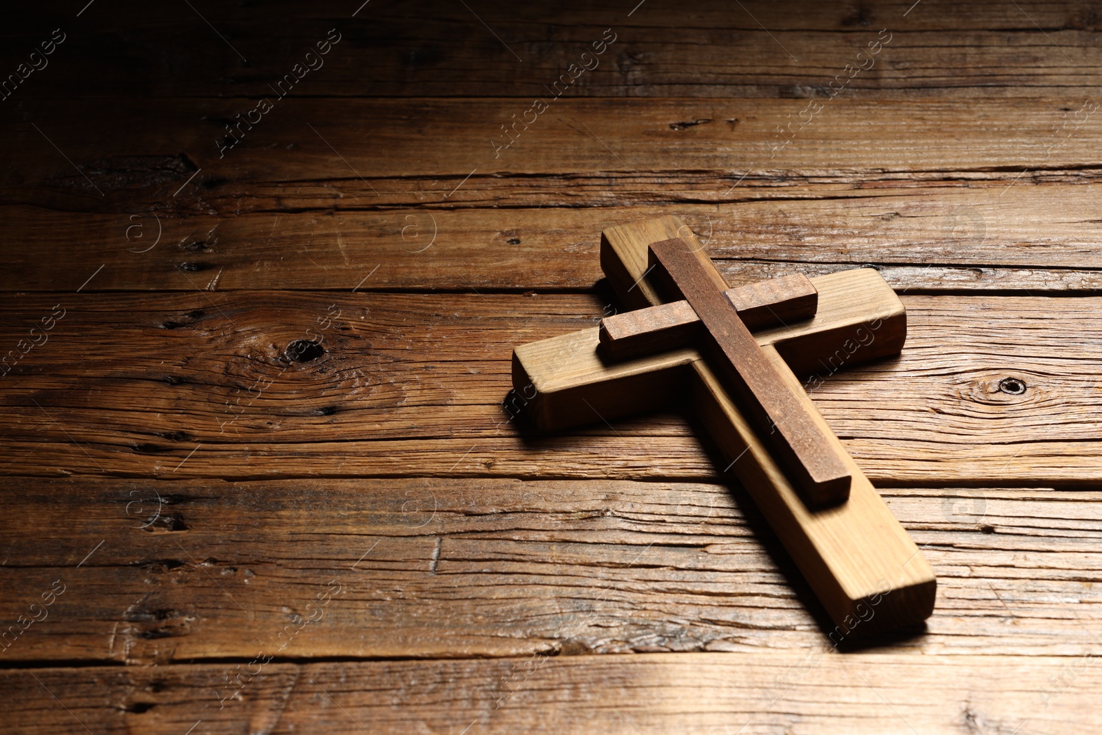 Photo of Cross on wooden table, space for text. Religion of Christianity