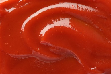 Photo of Tasty tomato ketchup as background, top view