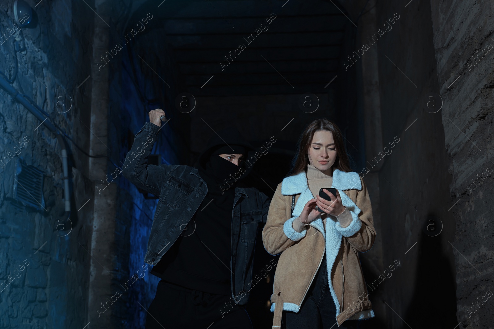 Photo of Criminal with knife attacking young woman in alley at night. Self defense concept
