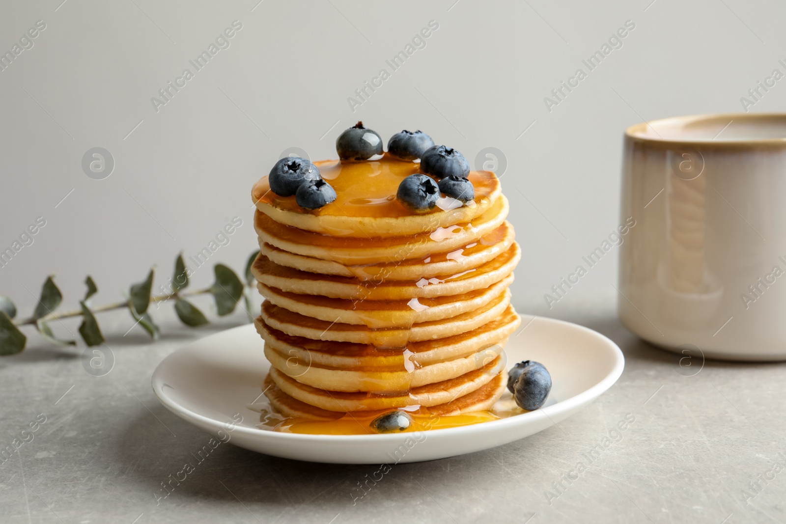 Photo of Plate with pancakes and berries on table