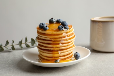 Photo of Plate with pancakes and berries on table