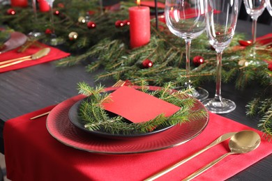 Photo of Elegant Christmas place setting with blank card and festive decor on table