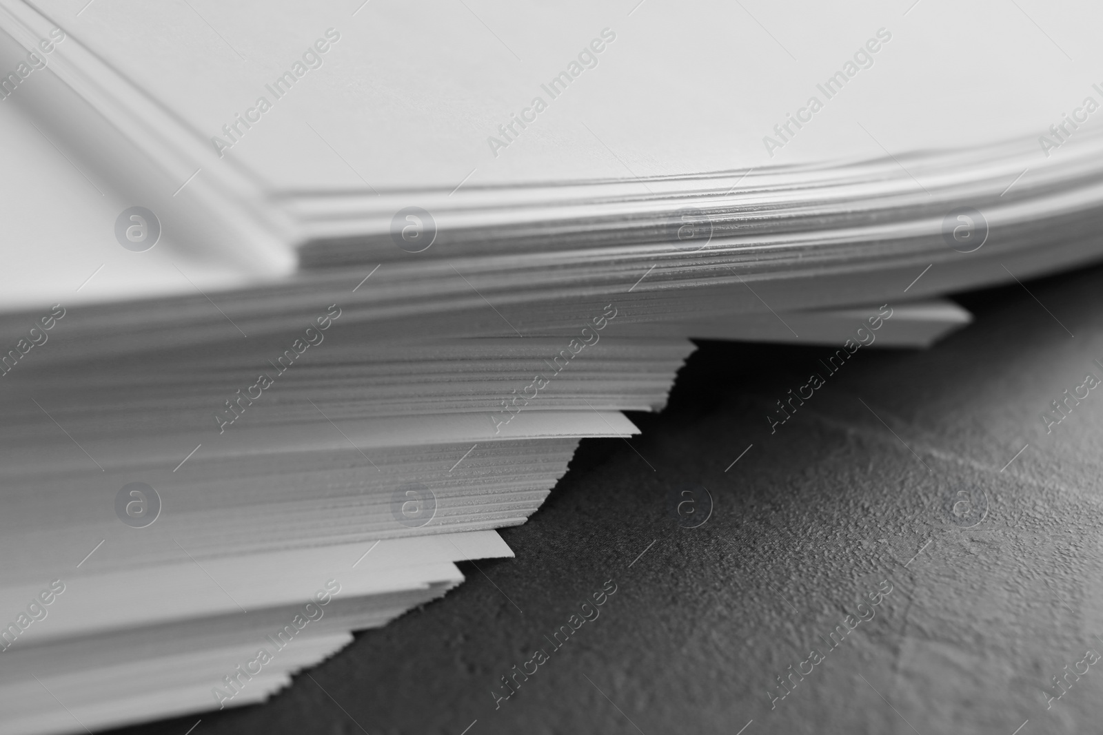 Photo of Stack of blank paper on grey stone table, closeup