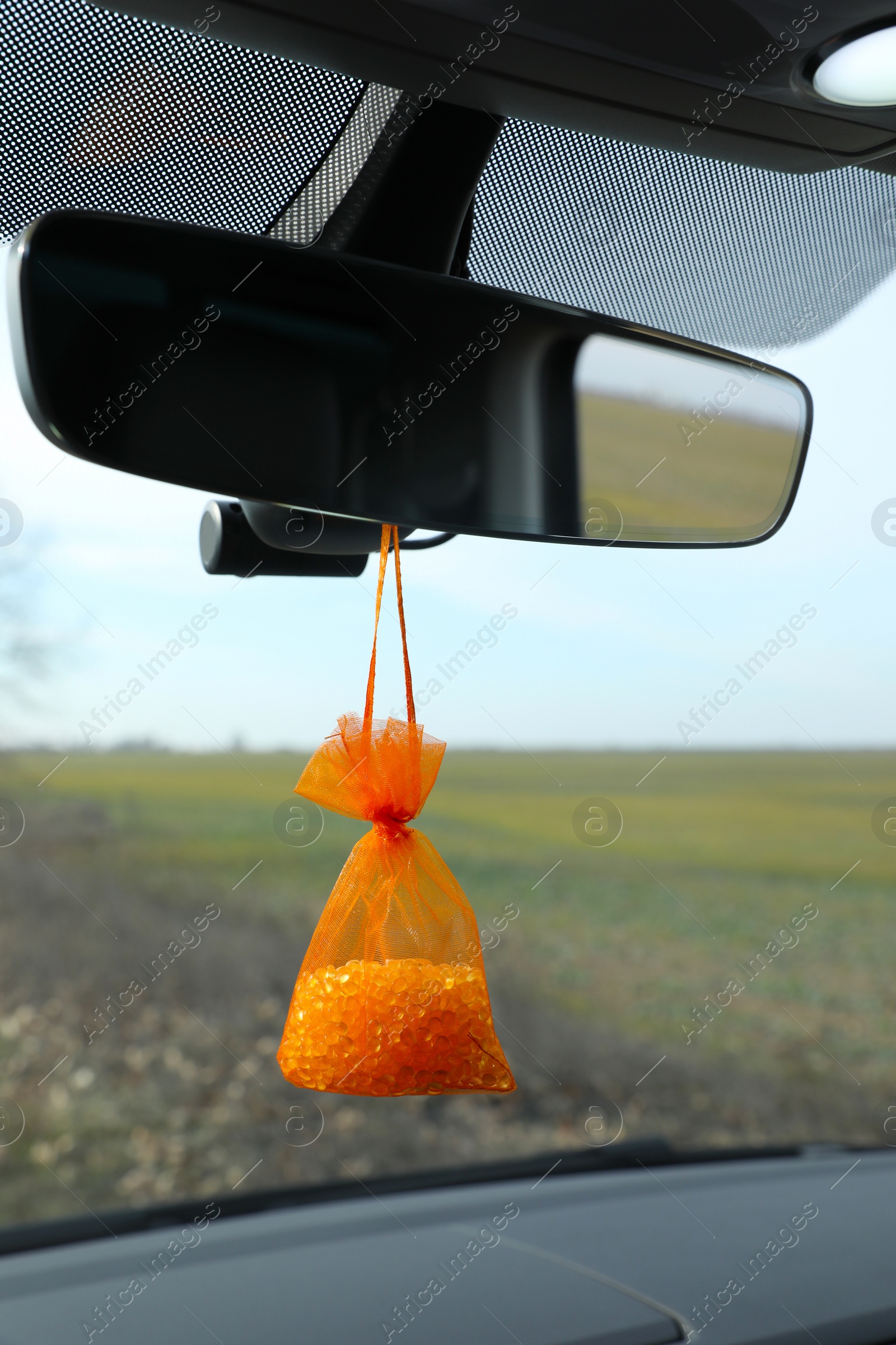 Photo of Air freshener hanging on rear view mirror in car