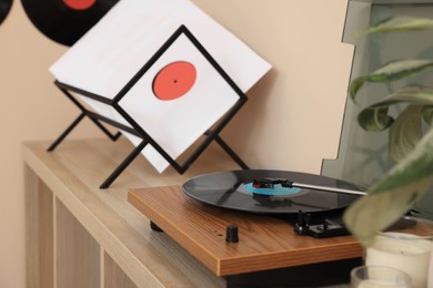 Vinyl record player on wooden table indoors