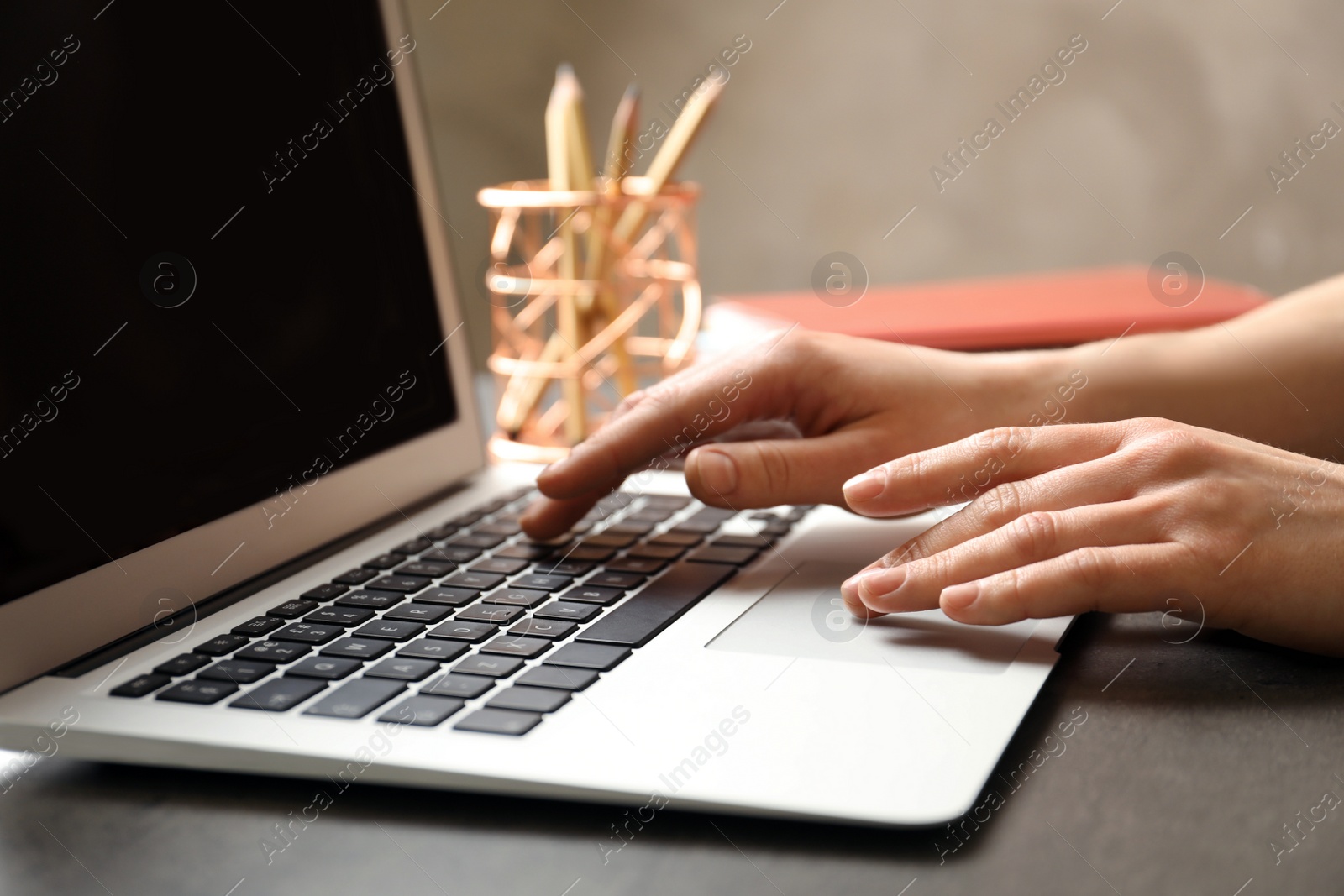 Photo of Woman using modern laptop at table, closeup