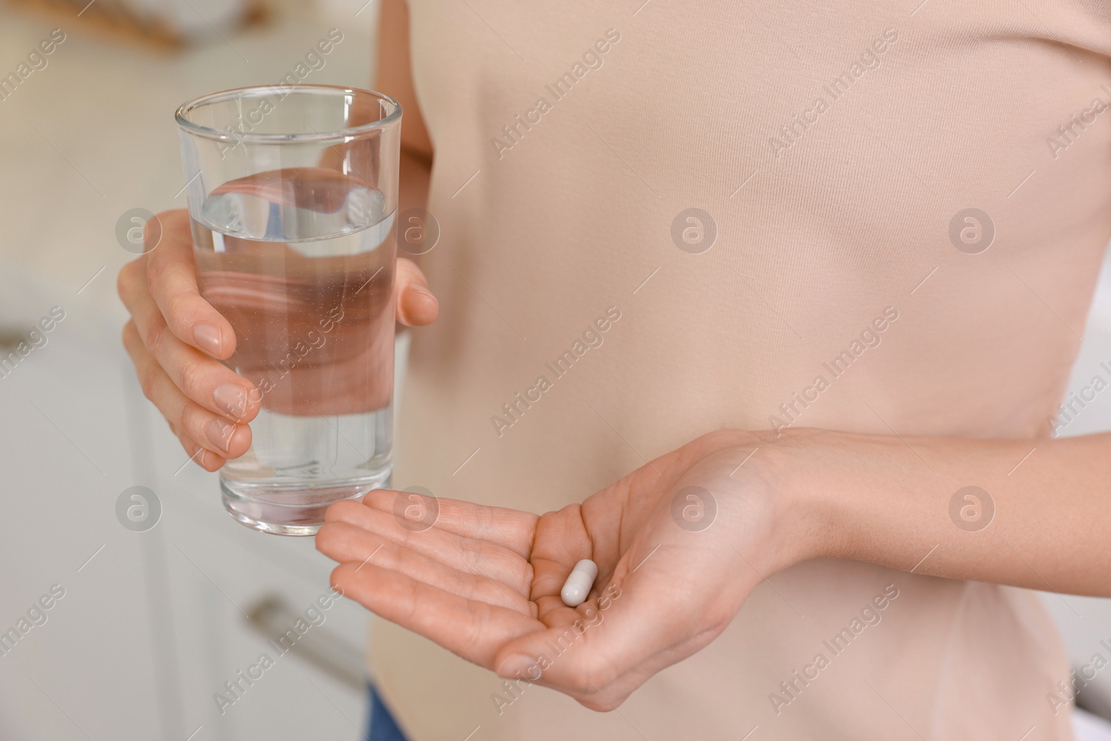 Photo of Beautiful young woman with vitamin pill and glass of water, closeup