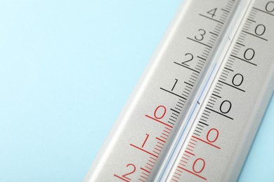 Weather thermometer on light blue background, closeup. Space for text