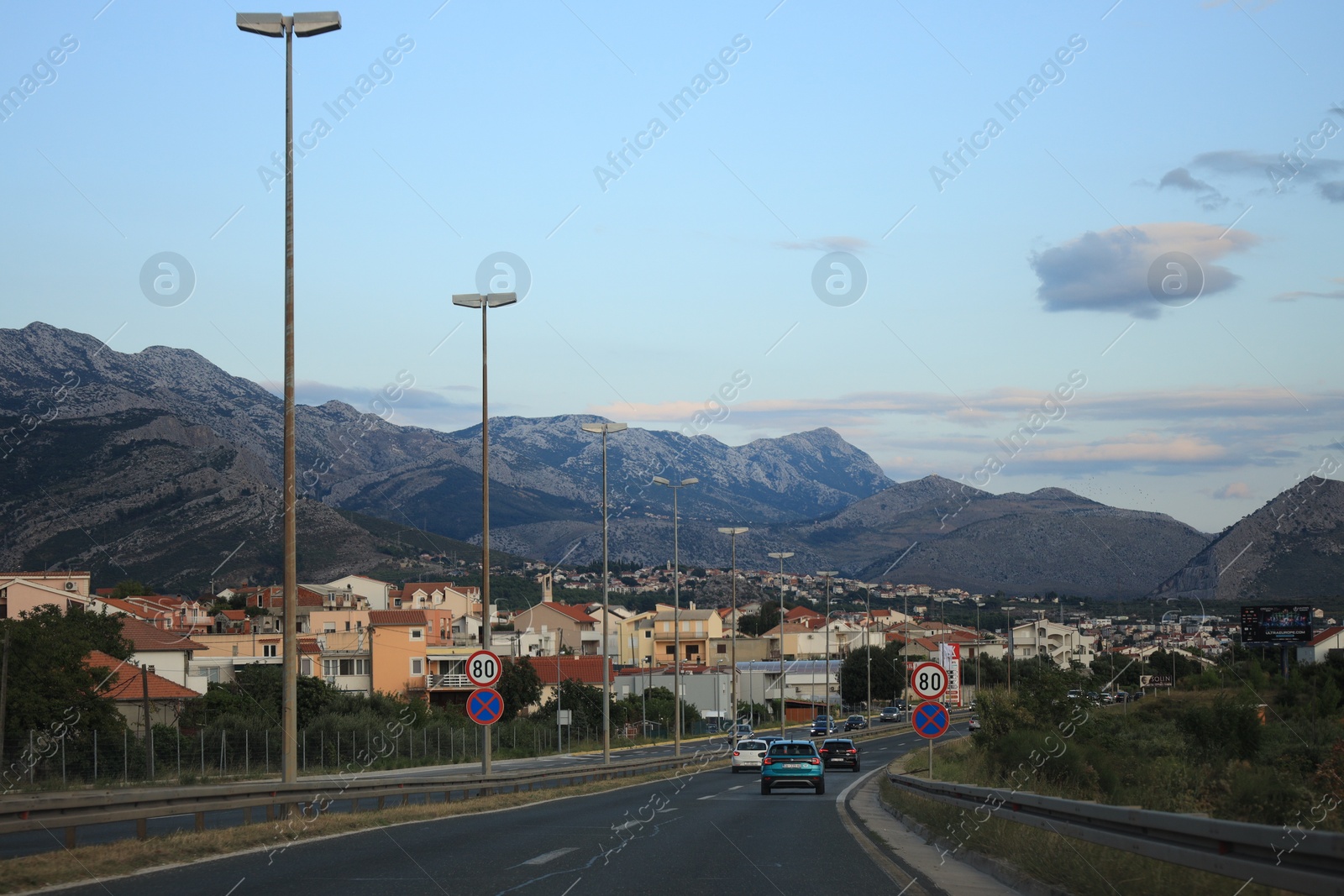 Photo of Picturesque view of mountains and highway with cars in city